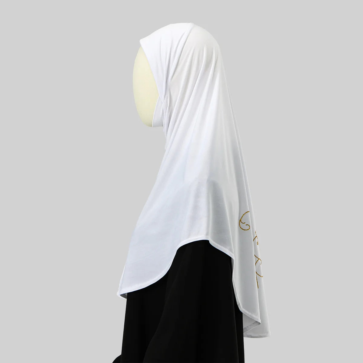 Hijab blanc avec broderie dorée portée sur un vêtement noir.