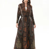 Una mujer modela un vestido vintage de estampado marrón oscuro largo con cuello desmontable y cinturón ajustable.