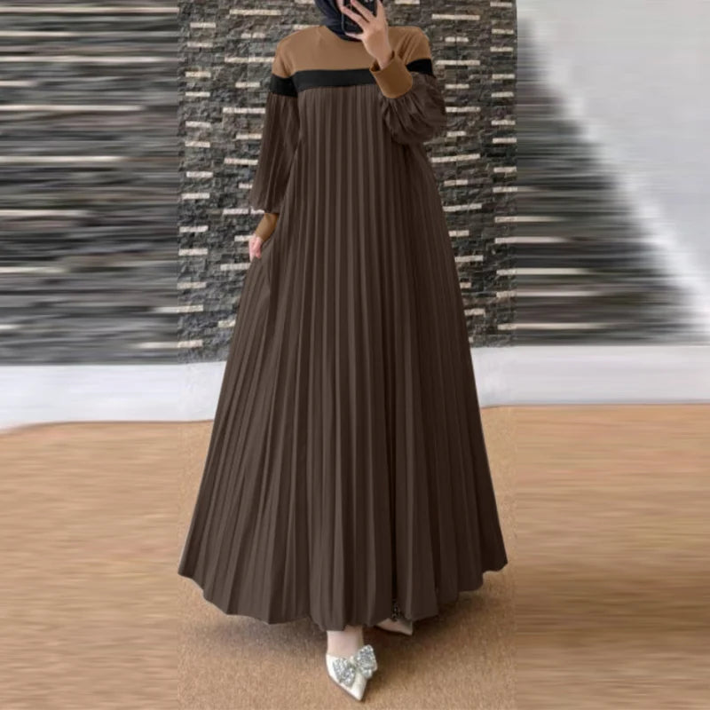 Une femme portant une longue caftan patchwork ample marron avec des manches foncées et un hijab noir.