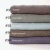 Pile de neuf foulards de hijab en coton viscose doux dans diverses nuances sourdes, dont roux, rose pâle, blanc glacé et aman