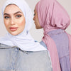 Una mujer vistiendo un hiyab azul claro instantáneo y un hiyab rosa, vista de perfil.