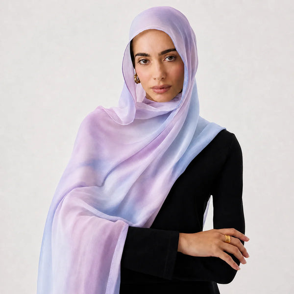 A woman wearing a light purple and blue premium cotton viscose hijab shawl.