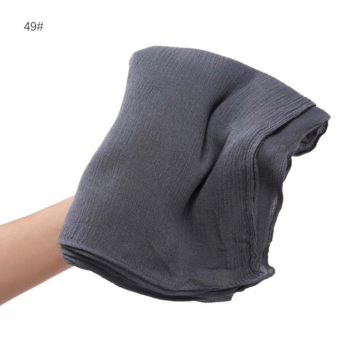 Un châle foulard en crinkle rayonne gris plié sur le bras d'une personne.