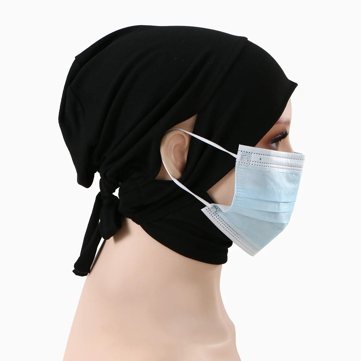 Eine Frau trägt einen schwarzen Hijab und eine hellblaue chirurgische Maske.