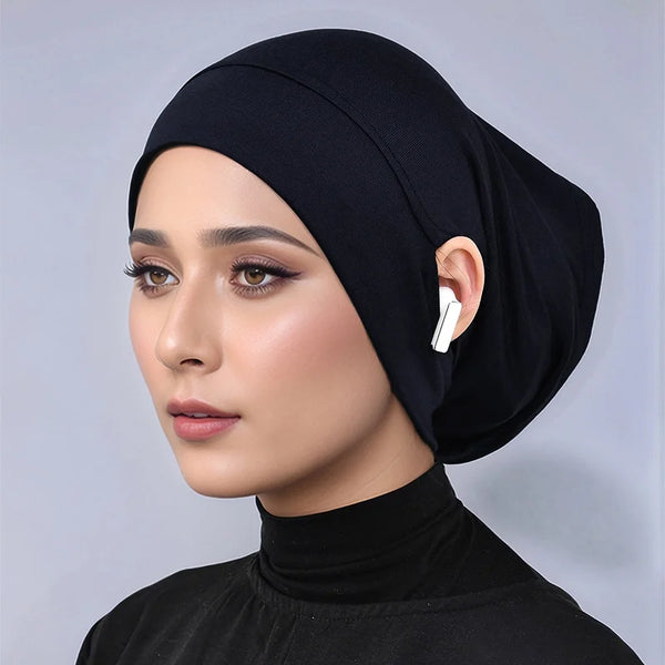 A woman wearing a black elegant jersey cotton hijab cap and black turtleneck top.