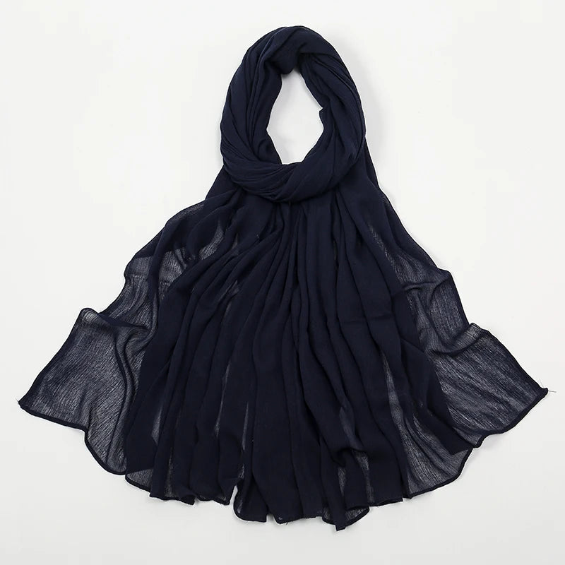 Étole cachemire bleu marine en crêpe, drapée élégamment.