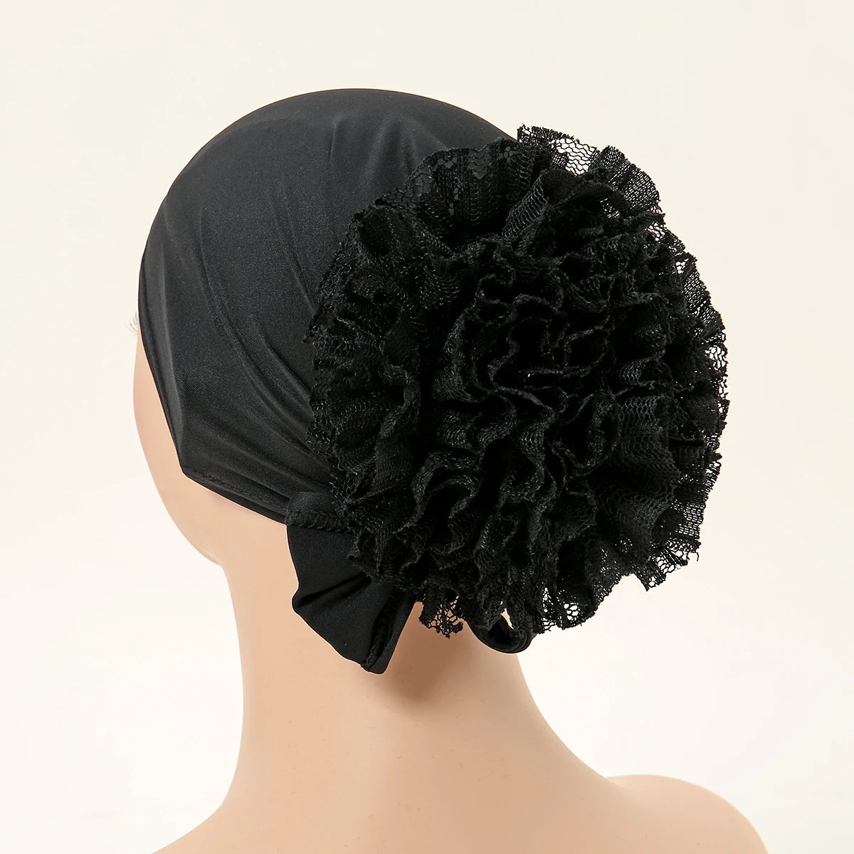Schwarzer Spitzenblumen-Volumizer-Hijab-Cap auf einem Mannequin-Kopf.