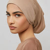 Modell trägt beige Bambus-Jersey-Turban-Kappe und passendes Oberteil, Profilansicht.