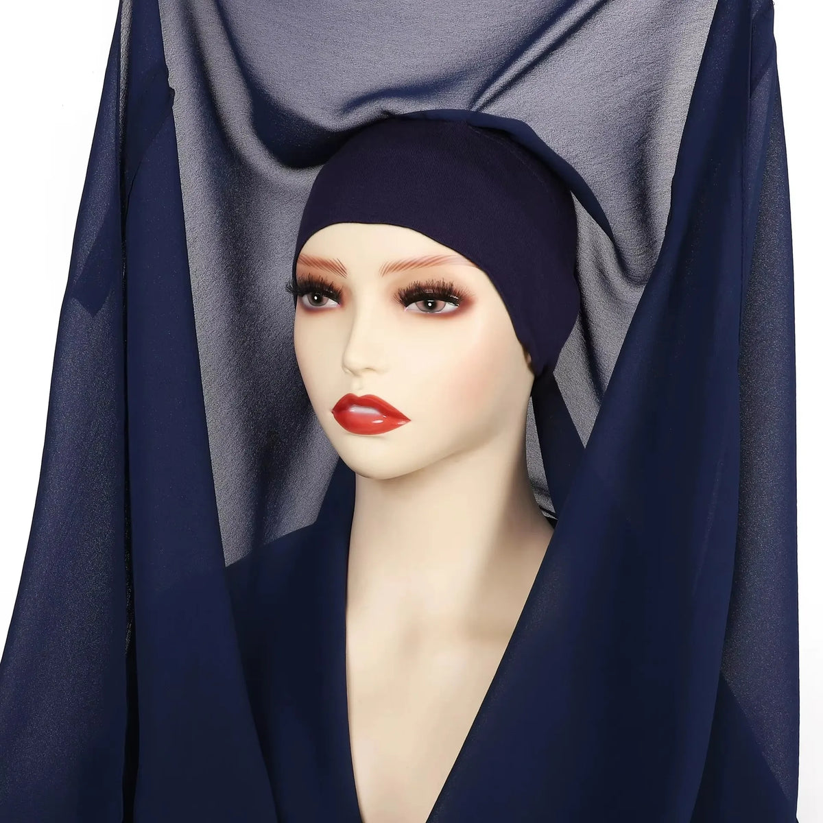 Model trägt einen dunkelblauen Chiffon-Hijab mit einer Magnetverschlüsse, drapiert über Kopf und Schultern.