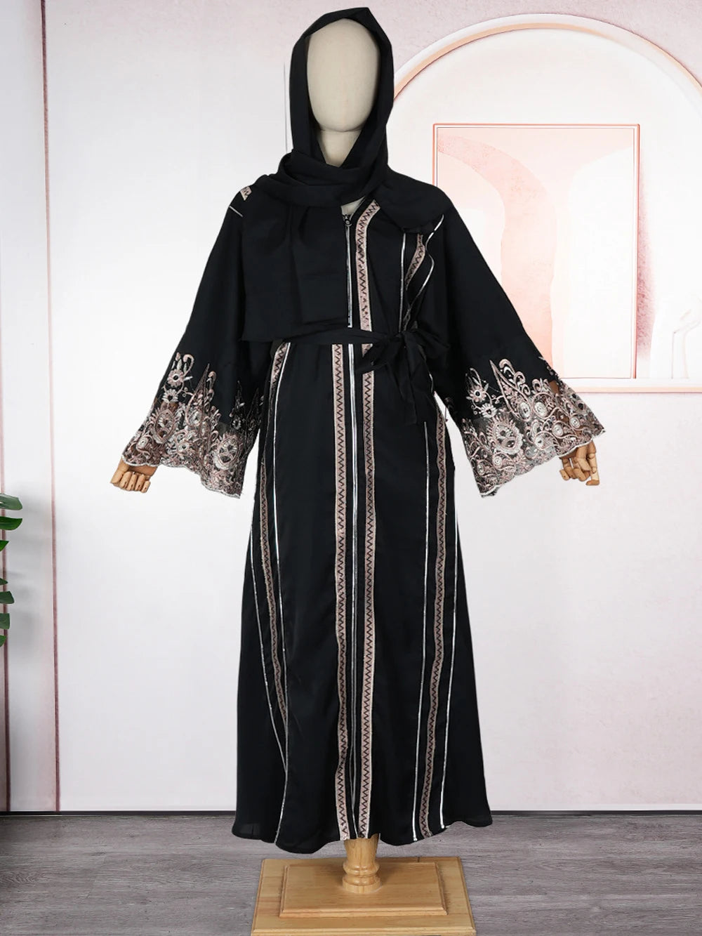 Vestido abaya negro de manga larga de lujo con bordado intrincado y capucha drapeada, exhibido en maniquí.