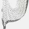 A white linen hijab scarf with black polka dots and black lace trim draped elegantly.