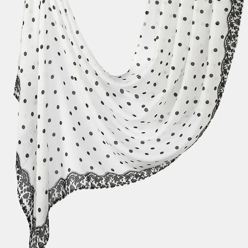 A white linen hijab scarf with black polka dots and black lace trim draped elegantly.