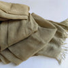 Une pile de foulards hijab en coton viscose vert olive avec pompons.