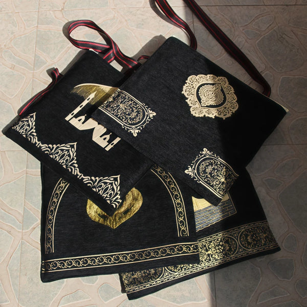 A black and gold dual set of prayer mats for Muslim worship with decorative patterns.