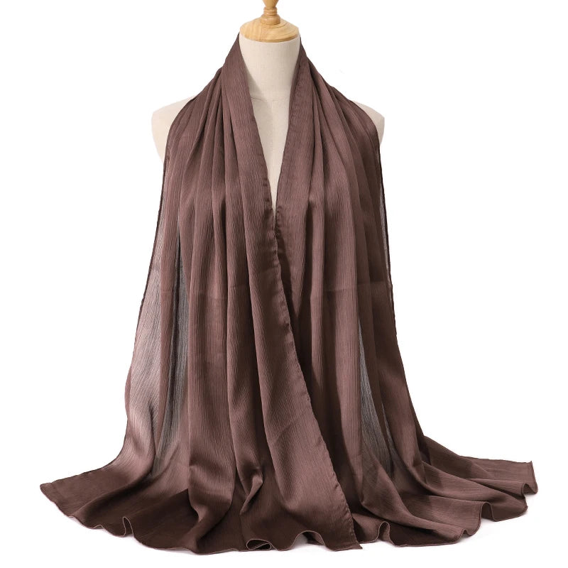 Gefaltener brauner Satin-Crinkle-Hijab-Schal auf einem Mannequin.