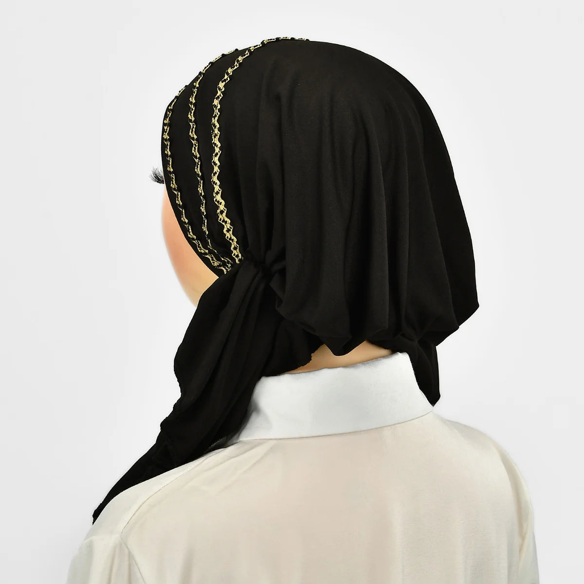 Eine Frau trägt einen schwarzen Hijab mit einem eleganten goldenen Streifen-Elastband