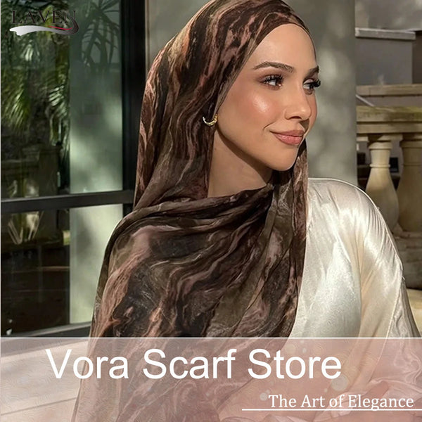 A woman wearing a brown and beige watercolor print scarf draped over her head, looking to the side.