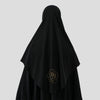 Un foulard hijab noir avec un motif de rose brodée dorée.
