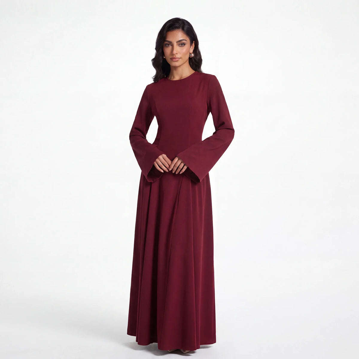 Una modelo vistiendo una elegante abaya de manga larga color granate para mujeres musulmanas.