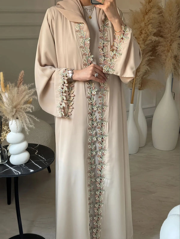 Elegant beige abaya featuring subtle leaf embroidery on the front placket.