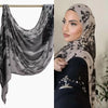 Eine Frau trägt einen schwarz-beigen Aquarelldruck-Baumwoll-Modal-Hijab-Schal über ihrem Kopf.