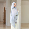 Eine Frau trägt einen eleganten bedruckten Baumwoll-Rayon-Hijabschal in hellblauen und grauen Tönen.