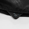 Nahaufnahme einer schwarzen wasserdichten Wanderhose mit einem Smartphone darunter.