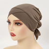 A model is wearing a solid brown adjustable cotton jersey inner hijab cap on her head.