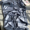 Fallendes, drapiertes, hellblaues Crinkle-Satin-Chiffon-Hijabgewebe in einer fließenden Falte.