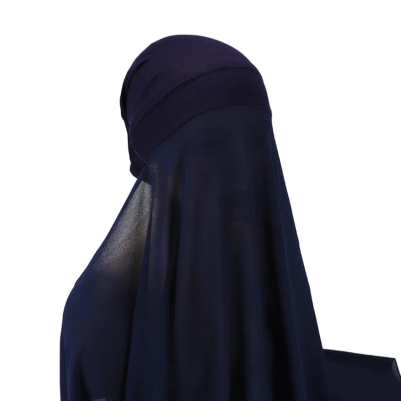 Un conjunto de hijab y chal de gasa instantánea azul marino oscuro drapeado sobre un hombro.