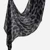 Durchsichtiger schwarz-grauer Leopard-Print-Leinen-Baumwoll-Hijab-Schal, über einer Oberfläche drapiert.