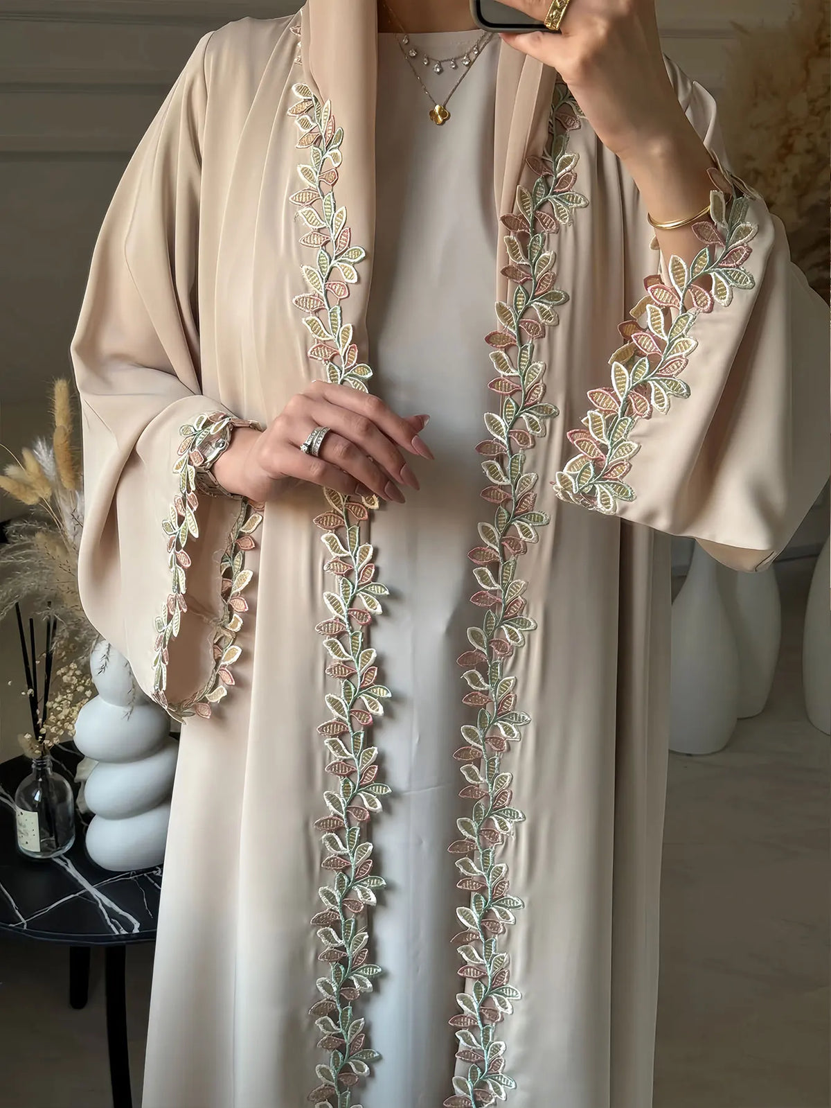 Elegante beige Abaya mit dezenter Blattstickerei am Frontplacket und an den Manschetten.