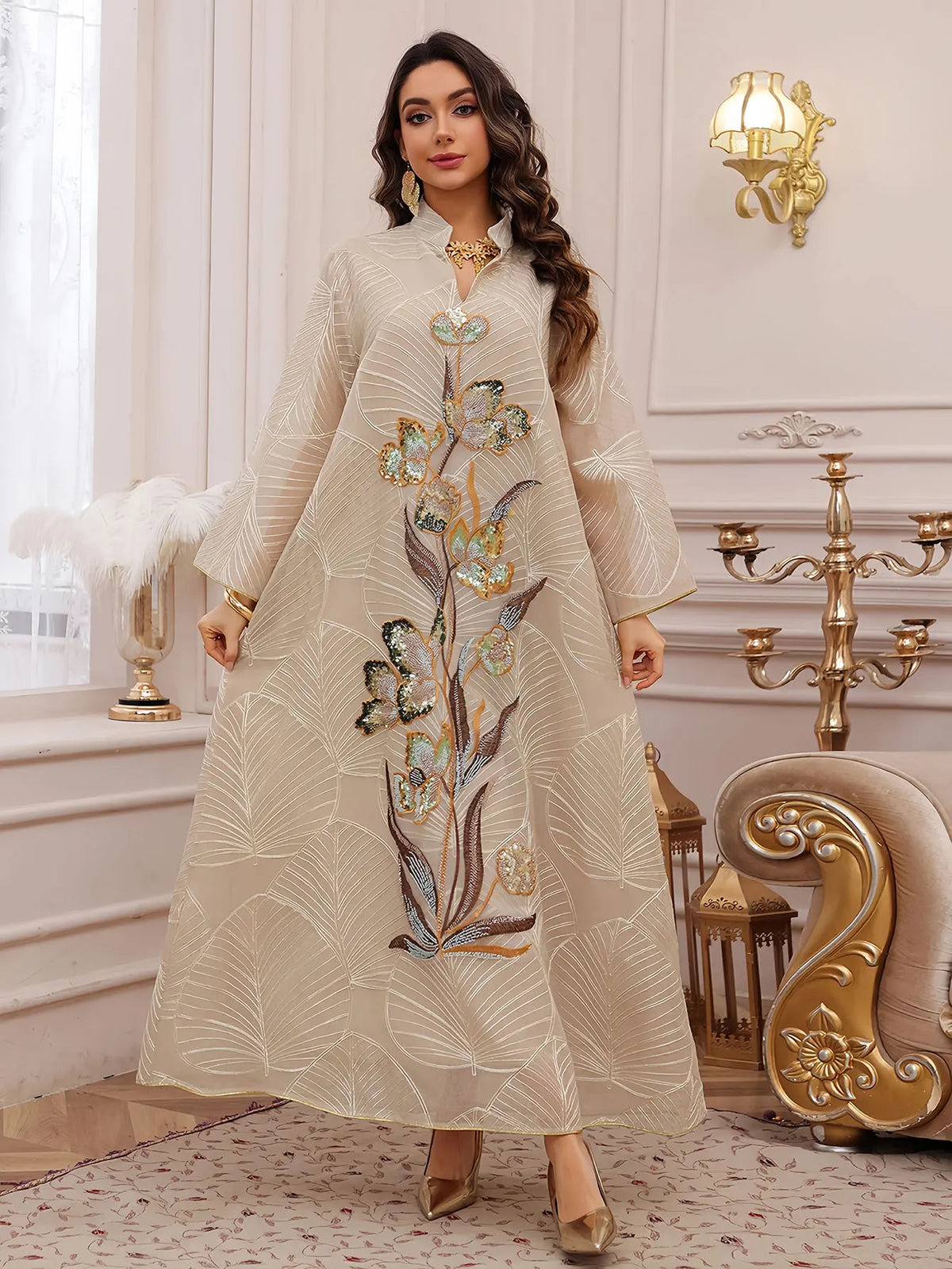 Eine Frau modelliert ein beige Abaya mit leichter Stickerei und Pailletten für Abendkleidung.
