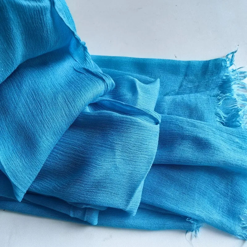 Foulard hijab en viscose coton bleu clair avec pompon, plié et drapé.