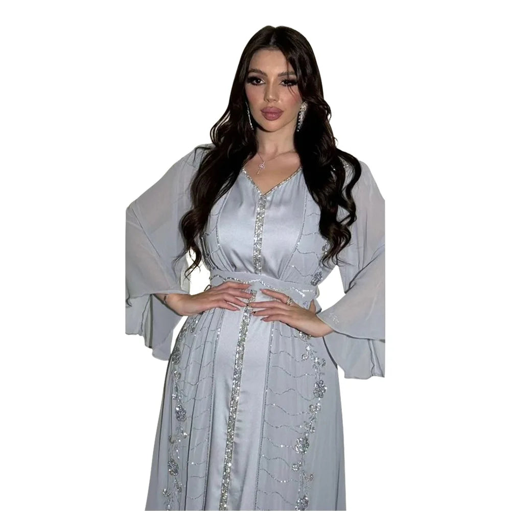 Eine Frau modelliert ein elegantes hellgraues zwei-teiliges muslimisches Set mit zarter silberner Stickerei und langen Ärmeln