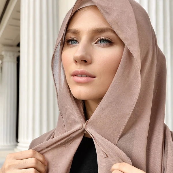 A woman wearing a beige instant chiffon hijab, looking directly at the camera.
