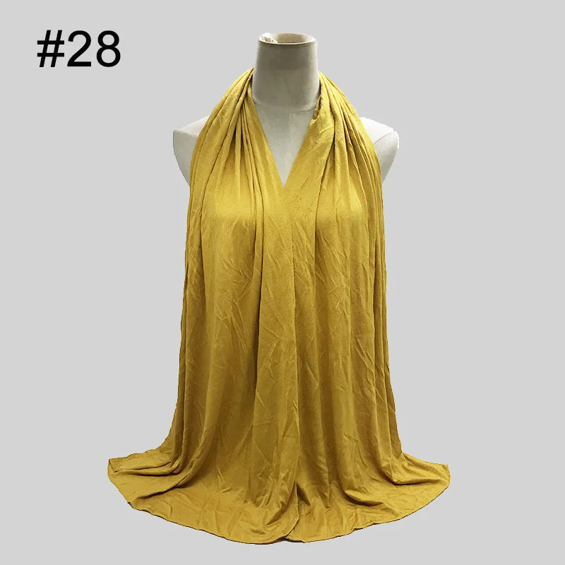 Senffarbener Baumwoll-Jersey-Hijabschal, drapiert um den Hals einer Mannequin.
