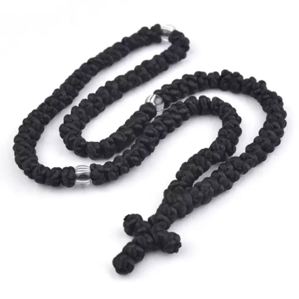 Black handmade Orthodox rosary prayer rope necklace coiled on a white background