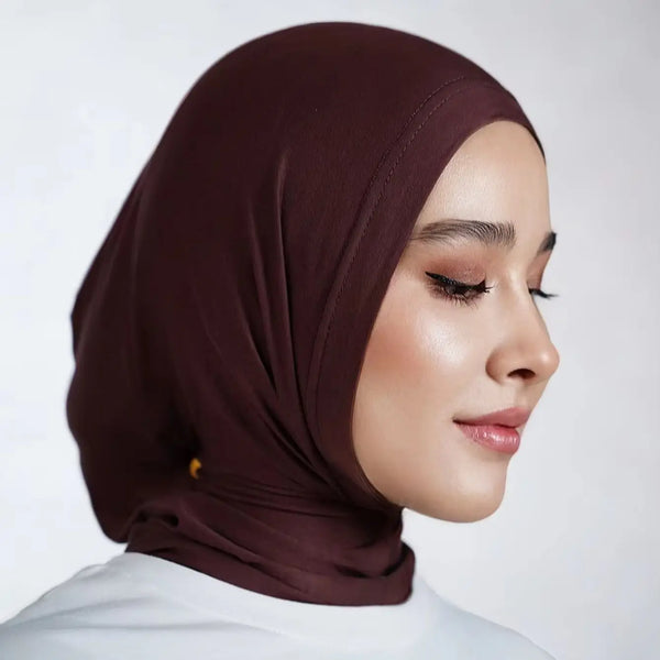 امرأة ترتدي حجابًا منسجًا فوريًا بني تحت غطاء الرأس الداخلي.
