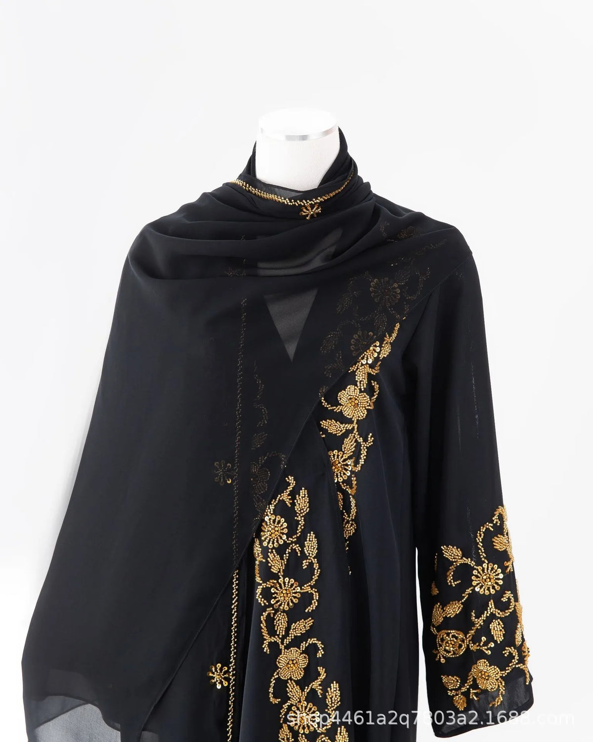 Black luxury abaya with gold floral beaded embroidery and a matching scarf displayed on a mannequin.