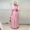 A woman models a pink elegant two-piece Arabic modest set with long sleeves and a high collar.