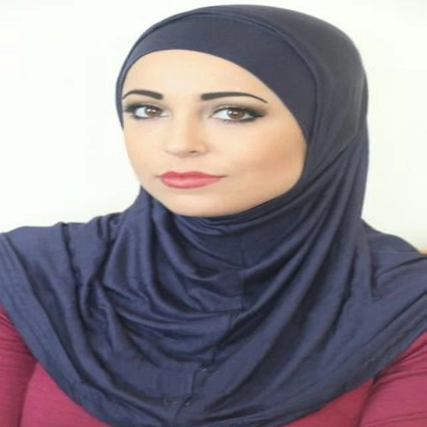 A woman wearing a dark blue modal cotton hijab scarf set looking directly at the camera.