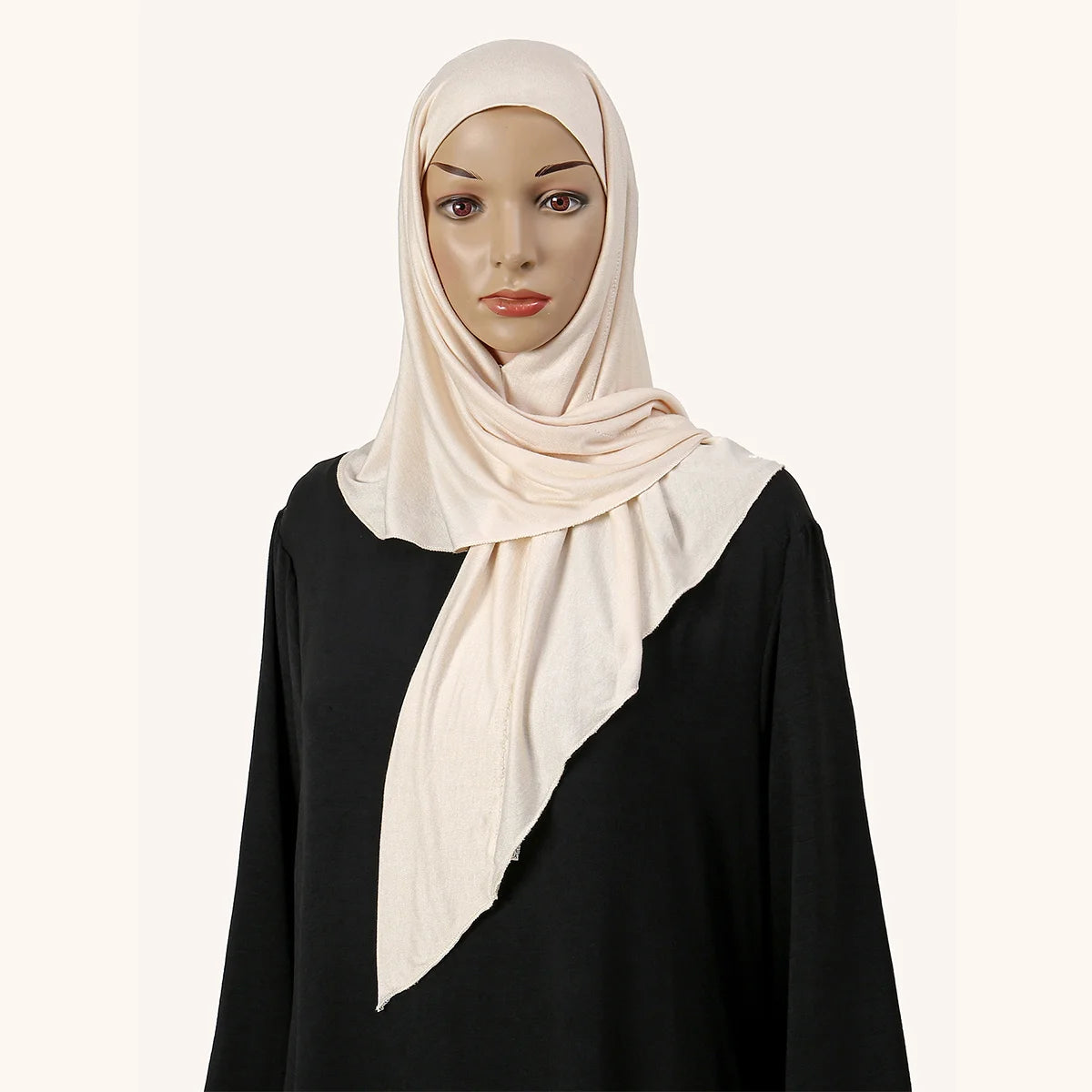 Eine Frau trägt einen hellrosa weichen Modal-Jersey Instant-Hijab-Schal über einem schwarzen Top.