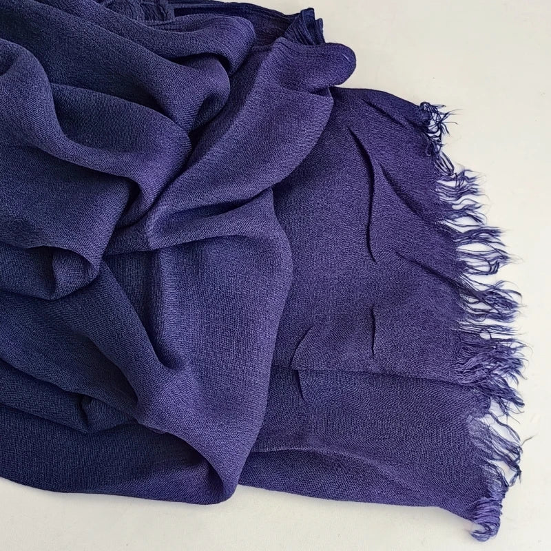 Foulard hijab en viscose coton violet profond avec une pompon drapé dans le tissu.