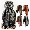 Un set de pañuelos de seda cuadrados con estampado de leopardo en patrones negro y marrón, mostrados planos y drapeados en el