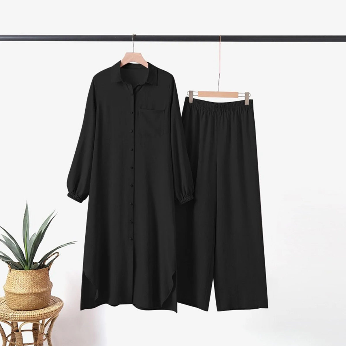 Conjunto de abaya de manga larga y botones para mujer negra colgado en una percha