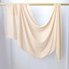 Écharpe de hijab beige uni drapée sur un cintre doré.