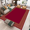 Una alfombra de área grande con patrón rojo y dorado en una sala de estar con muebles modernos.