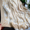 Beige Viskose-Schal mit Blumenmuster und goldenen Akzenten, sanft drapiert.