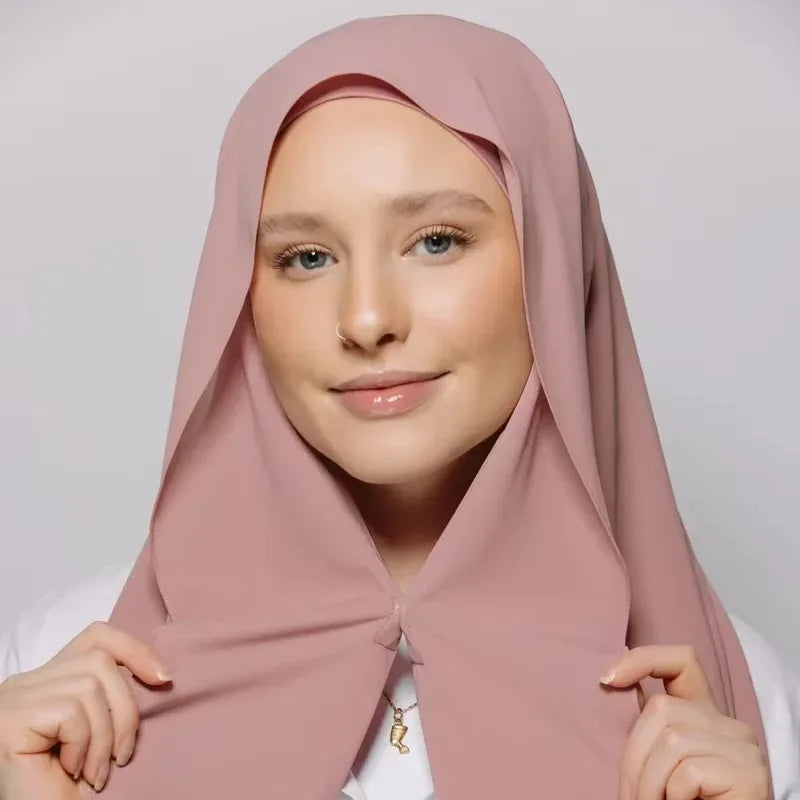 Eine Frau trägt einen staubrosa Chiffon-Instant-Hijab mit eingebauten Magneten.